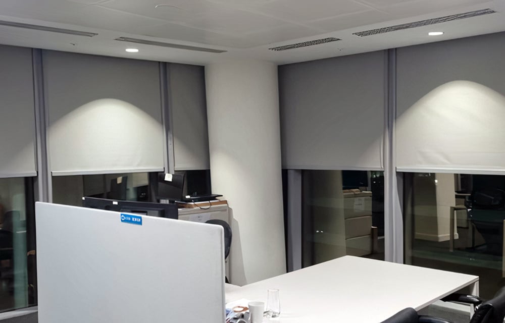 Image of desk in front of blinds using fabrics optimised for energy efficiency 